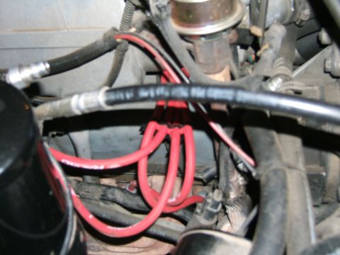 1991 Ford Bronco - Close-up view of red spark plug wires in an engine bay.