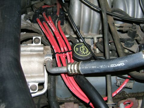 1991 Ford Bronco - Close-up view of engine components, including red spark plug wires and various hoses.
