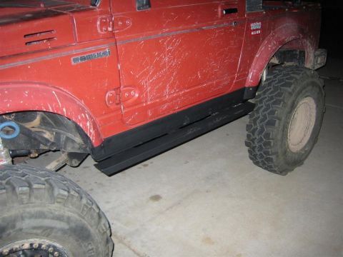1987 Suzuki Samurai - This red Suzuki Samurai features aftermarket side steps and tires, suggesting it's ready for off-road adventures.