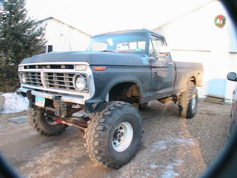 1977 Ford F-250 - This lifted 1977 Ford F-250 pickup truck features a prominent grille and large off-road tires.