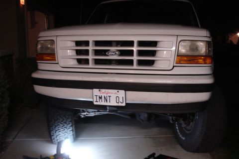 1996 Ford Bronco - The front grille and headlights of a white Ford truck are visible in this nighttime photo.