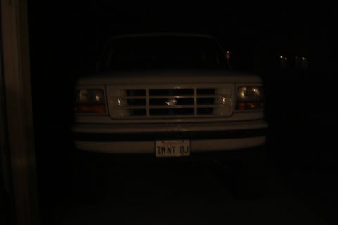 1996 Ford Bronco - Front view of a white Ford truck at night, showing its grille and license plate.