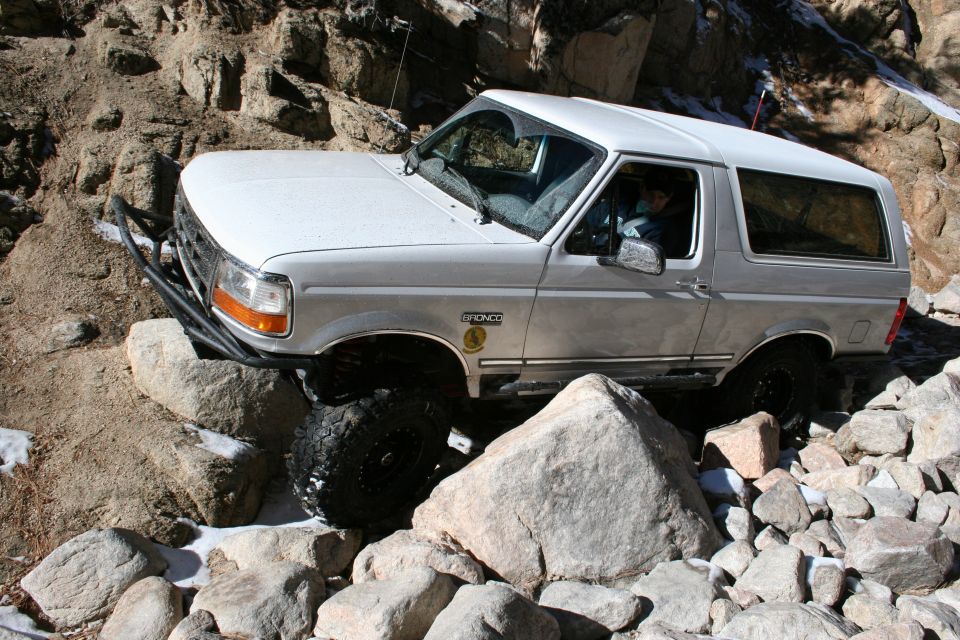 White 1996 Ford Bronco navigating a rocky trail