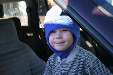 1996 Ford Bronco - A child wearing a blue hat smiles while sitting in the interior of a vehicle.