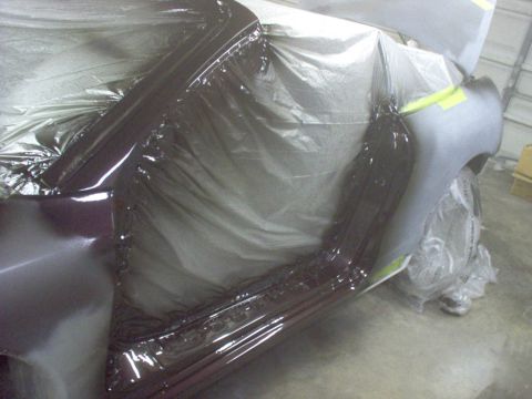 1994 Ford Probe - Car body panel covered in plastic sheeting during painting process.