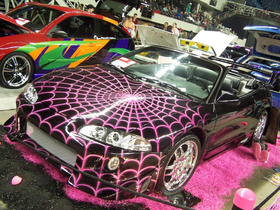 Black convertible with pink spider web graphics and chrome wheels