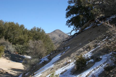 1996 Ford Bronco - A scenic view of a mountain landscape with scattered snow and vegetation under a bright blue sky.
