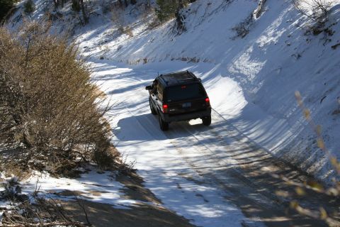 1996 Ford Bronco - SUV navigates a snowy mountain road in winter conditions.