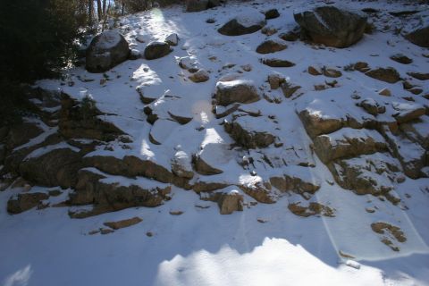 1996 Ford Bronco - Snowy hillside with rocks and trees, sunbeams breaking through.
