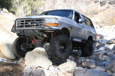 1996 Ford Bronco - This modified 1996 Ford Bronco tackles a challenging off-road course, demonstrating its capabilities on a rocky trail.