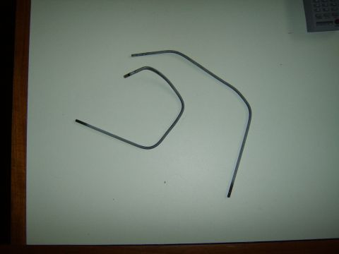 1989 Ford Bronco - Two bent metal rods are shown on a white background.