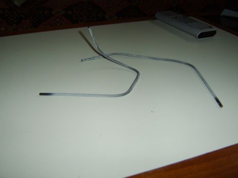 1989 Ford Bronco - Two welding rods are shown on a flat surface, with a remote control in the background.
