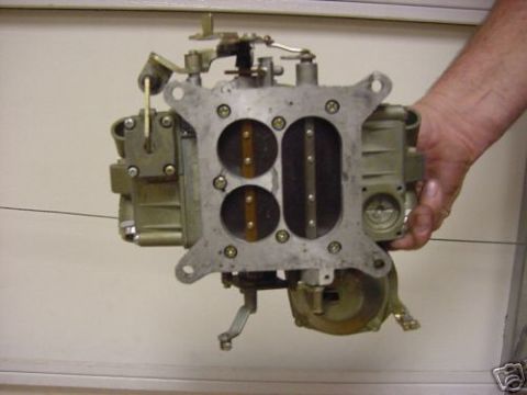 1972 Ford Ranchero - A hand holds a carburetor, a critical engine component for mixing air and fuel.