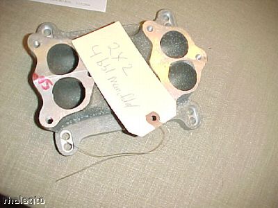 1972 Ford Ranchero - A metal intake manifold with two pairs of circular openings is shown, with a handwritten tag attached.