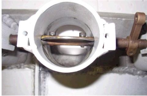 1972 Ford Ranchero - Close-up view of a vehicle's throttle body assembly, showing internal components and external linkage.