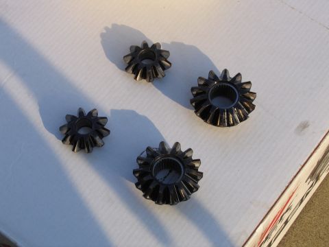 1989 Ford Bronco - Four gears are laid out on a white surface, casting shadows.