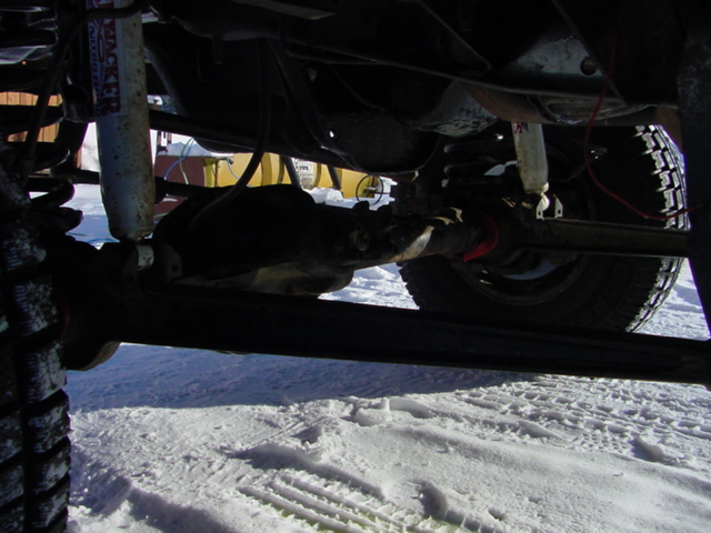 Undercarriage view of a vehicle with a shock absorber and suspension components visible