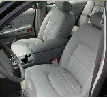 2001 Ford Crown Victoria - The light-colored cloth interior of a car, showing the front seats and dashboard area.