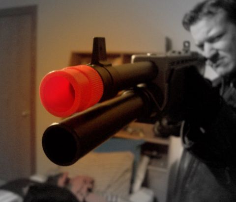 1988 Mercury Grand Marquis - A toy gun with a bright red muzzle is pointed towards the camera, with a man visible in the background and a Supermotors.net logo in the co…