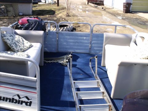 1983 Ford Bronco - Interior view of a pontoon boat, blue carpeting, white seating, and a retractable ladder.