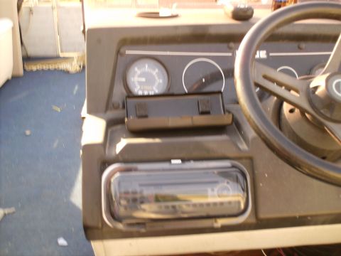 1983 Ford Bronco - Close-up of a boat's dashboard, showing the steering wheel and gauges.