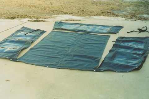 1978 Ford Bronco - Soft top components, likely for a convertible or SUV, are spread out on a paved surface.