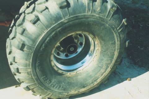 1978 Ford Bronco - Close-up view of a large off-road tire mounted on a chrome rim.