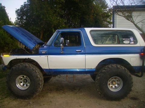 1978 Ford Bronco - This lifted Ford Bronco has oversized tires and its hood is open, revealing the engine compartment.