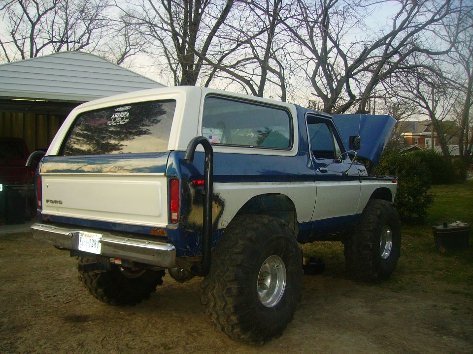 Blue and white 1978 Ford Bronco rear 3/4 view with lifted suspension and large off-road tires