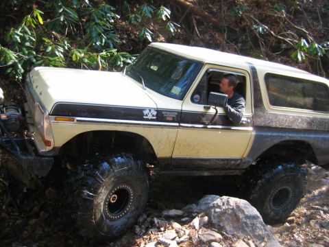 1992 Ford Mustang - A man drives a lifted 1978 Ford Bronco through a challenging, wooded off-road course.