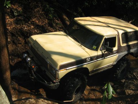 1992 Ford Mustang - Ford Bronco navigating a challenging muddy off-road trail.