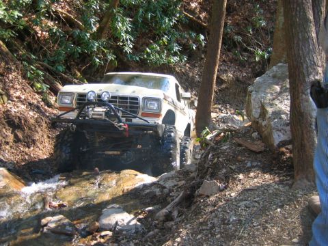 1992 Ford Mustang - This lifted Ford Bronco navigates a challenging off-road trail with water and rocks.