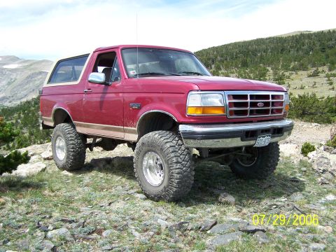 1995 Ford Bronco - Modified 1995 Ford Bronco on a mountain trail, equipped for off-road adventures.