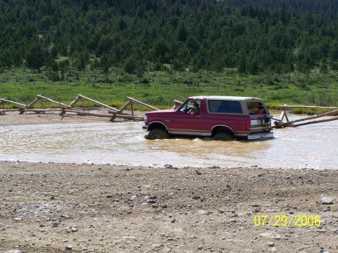 1995 Ford Bronco - This Ford Bronco appears to be from the early to mid-1990s, not a 1995 model, as it navigates through a shallow body of water.