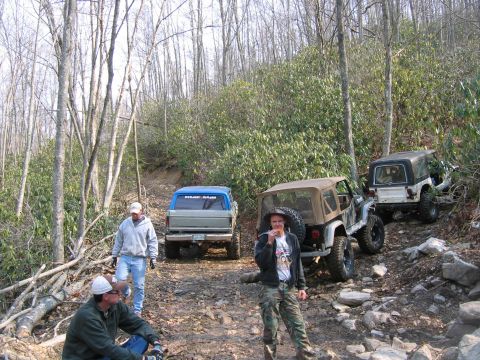 1992 Ford Mustang - Off-roading adventure with multiple vehicles navigating a challenging wooded terrain.