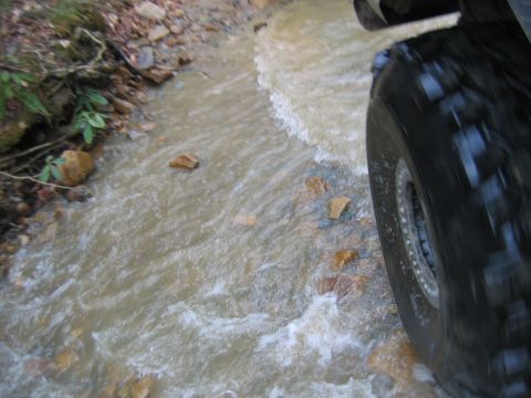 1992 Ford Mustang - Driving through a rocky stream, the tire kicks up water and splashes over the rocks.
