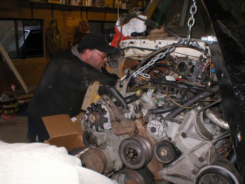 1978 Ford Bronco - Engine removal in progress, mechanic attending to the V8 motor.