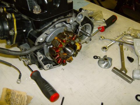 1982 Chevrolet C/K Pickup - A motorcycle engine's stator is shown disassembled on a workbench with various tools.