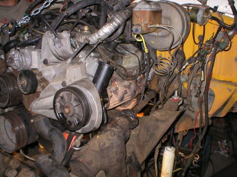 1978 Ford Bronco - Close-up view of an engine bay, focusing on the V-belt pulleys and brake fluid reservoir, with extensive wiring visible.