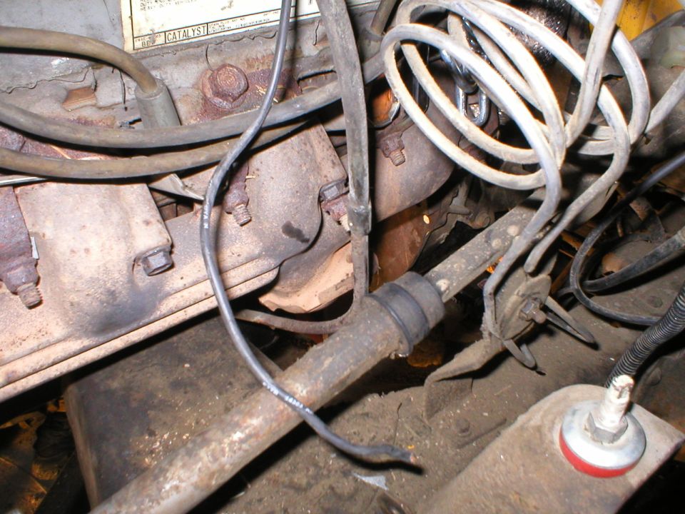 Rusty engine bay showing hoses, corroded brackets, bolts and metal lines