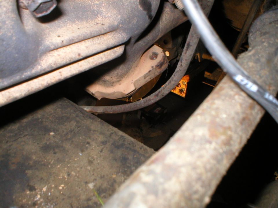 Rusty undercarriage component with hose and bolted housing on old Ford Bronco