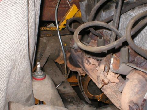 1978 Ford Bronco - This image shows a close-up view of an engine bay, focusing on the exhaust manifold and associated wiring, with some visible rust.