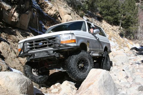 1996 Ford Bronco - A modified Ford Bronco tackles a challenging rocky trail in a mountainous area.