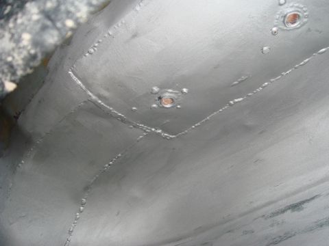 1996 Ford Bronco - Underbody repair work with visible welds and rivets, painted silver.