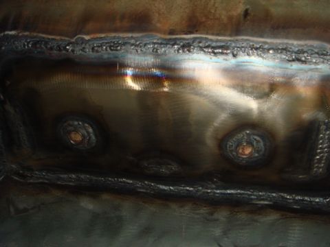 1996 Ford Bronco - Close-up view of welded metal with circular fasteners, likely part of a vehicle repair.