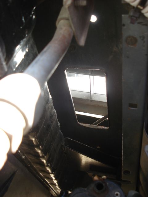 1986 Ford Bronco - A close-up view of a vehicle's frame reveals a section with a prominent rectangular cutout.
