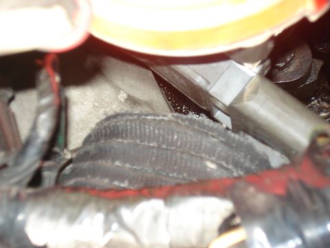 1986 Ford Bronco - Close-up view of an engine component with a black ribbed hose and metal fittings.
