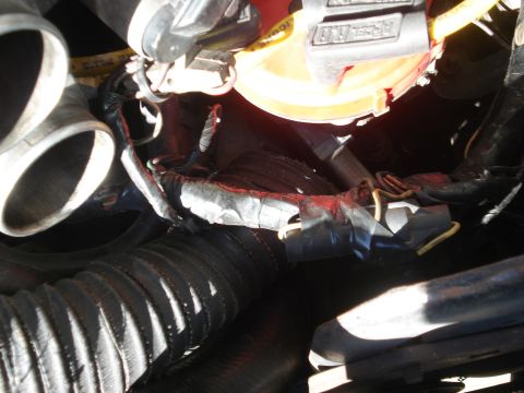 1986 Ford Bronco - Close-up view of a taped engine bay wiring harness with exposed yellow wires.