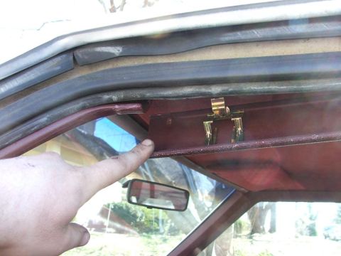 1991 Ford Crown Victoria LTD - A finger points to a metal clip on the interior door frame, near the weatherstripping.