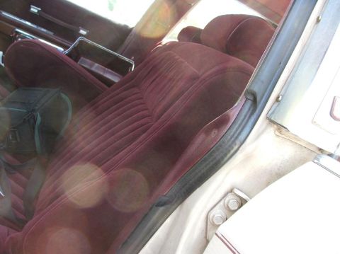 1991 Ford Crown Victoria LTD - The interior of a car features plush maroon velour seats and a portion of the door panel.
